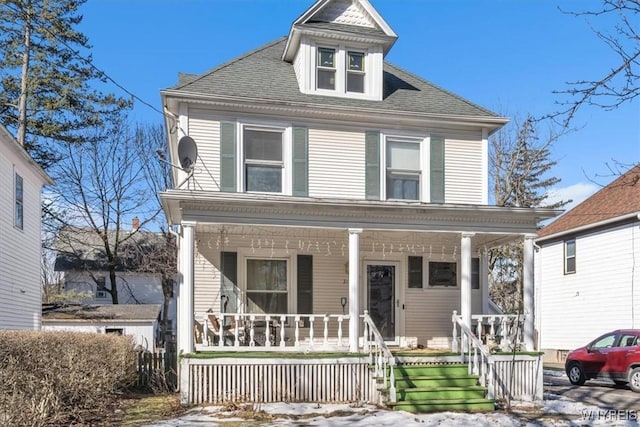 traditional style home featuring a shingled roof and a porch