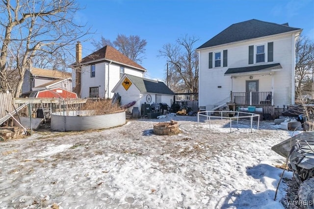 rear view of house featuring a chimney and a fire pit