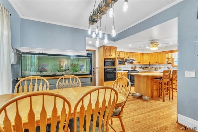 dining area with a ceiling fan, crown molding, light wood-style flooring, and baseboards