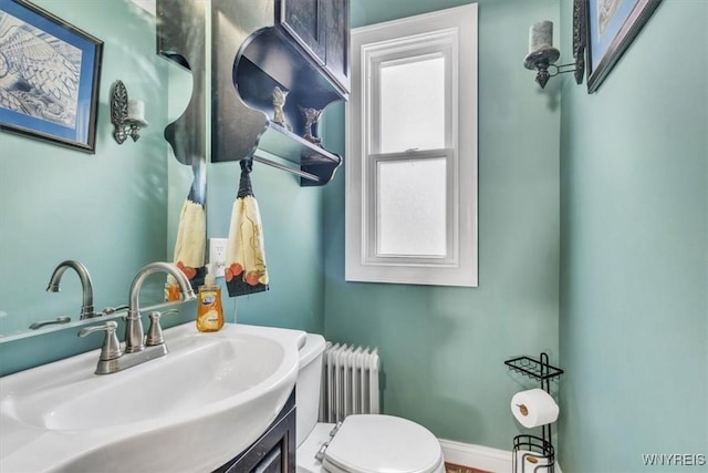 bathroom featuring radiator, baseboards, vanity, and toilet