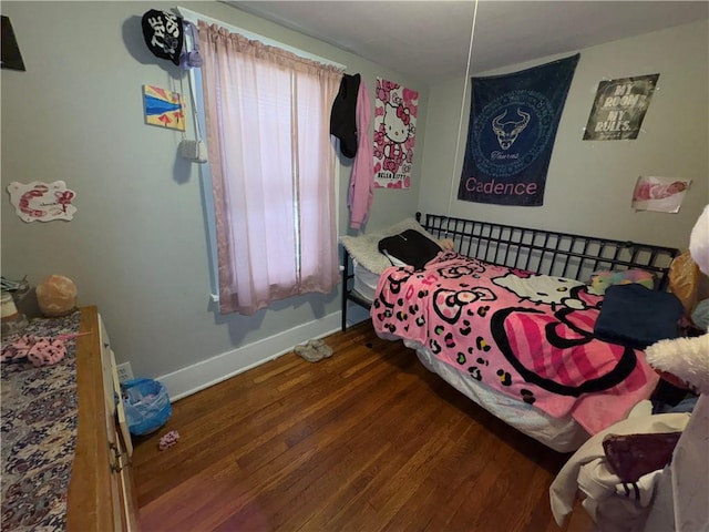 bedroom with baseboards and wood finished floors