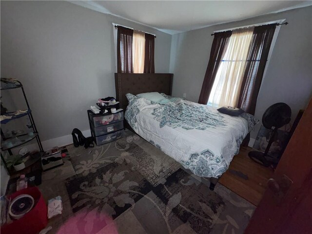 bedroom with baseboards and wood finished floors