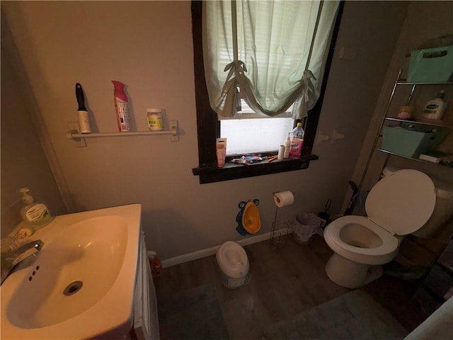 bathroom featuring vanity, wood finished floors, toilet, and baseboards