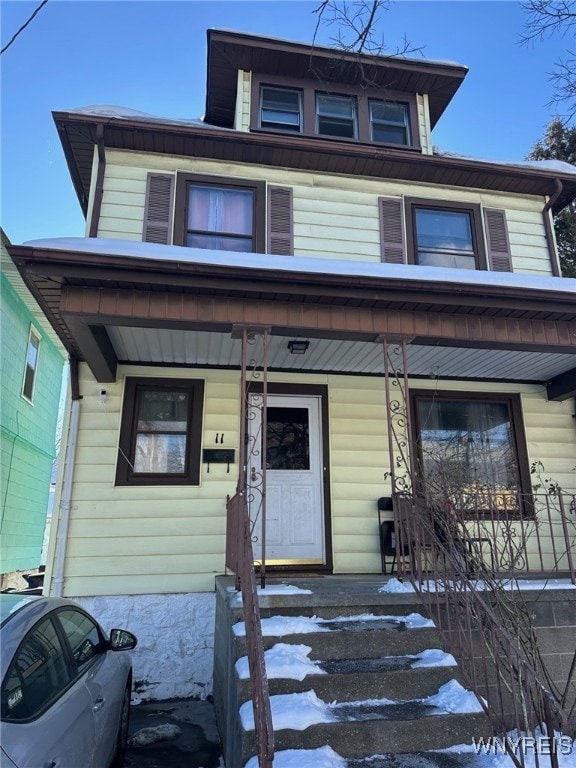 american foursquare style home with a porch