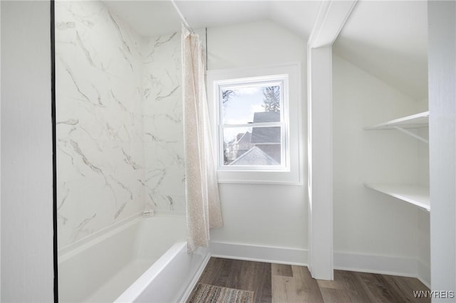 bathroom featuring shower / bath combo with shower curtain, baseboards, vaulted ceiling, and wood finished floors