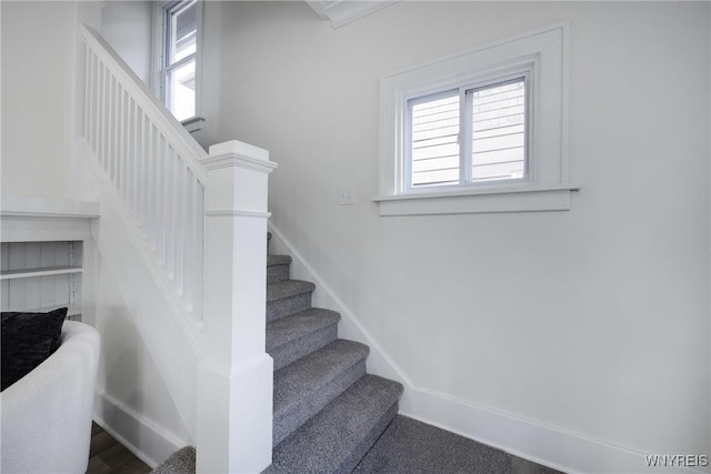 staircase with plenty of natural light and baseboards