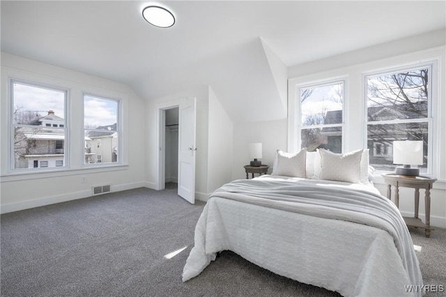 bedroom featuring baseboards, visible vents, vaulted ceiling, and carpet flooring