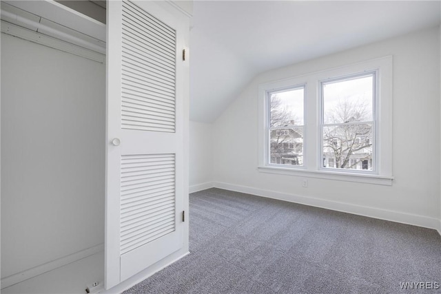 additional living space with carpet floors, baseboards, and vaulted ceiling