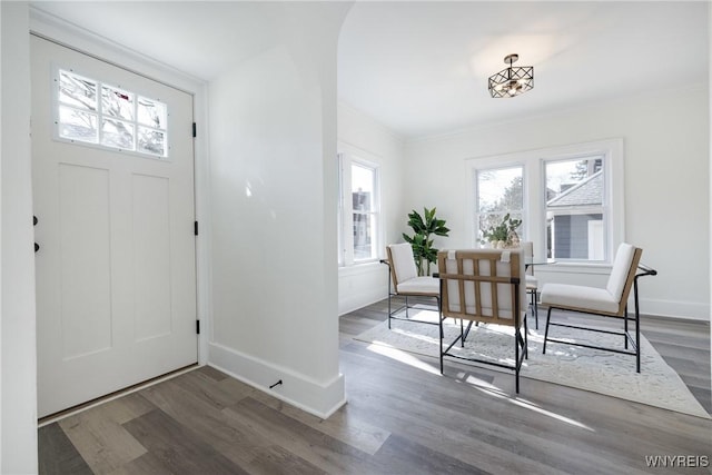 entryway with ornamental molding, baseboards, and wood finished floors