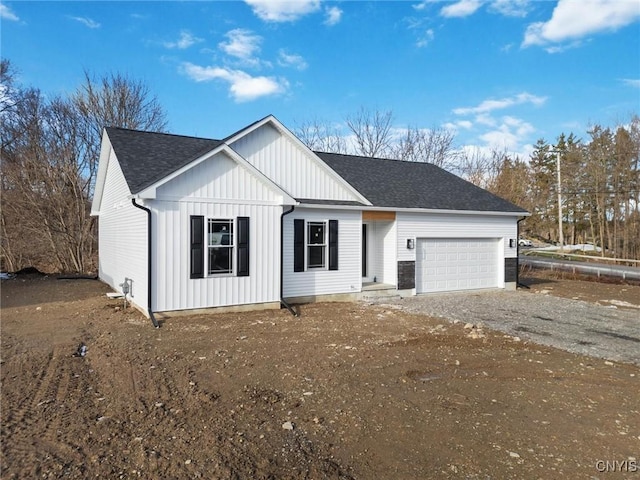 view of front of property featuring an attached garage, driveway, board and batten siding, and roof with shingles