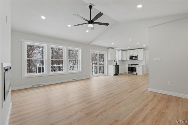 unfurnished living room with lofted ceiling, light wood-style flooring, visible vents, and a ceiling fan