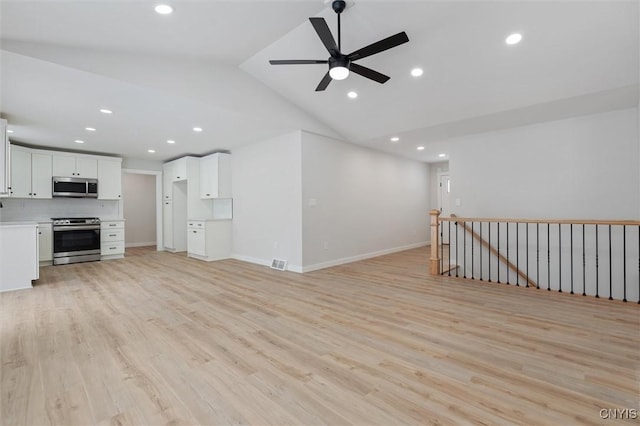 interior space with light wood finished floors, baseboards, ceiling fan, vaulted ceiling, and recessed lighting