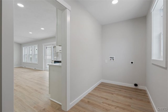 laundry room with hookup for a washing machine, light wood-style flooring, electric dryer hookup, and baseboards