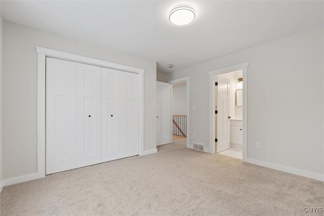 unfurnished bedroom with carpet floors, a closet, visible vents, and baseboards