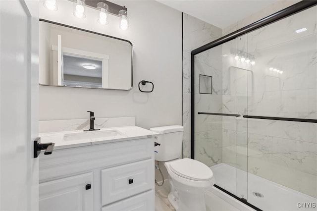 bathroom with toilet, vanity, and a marble finish shower