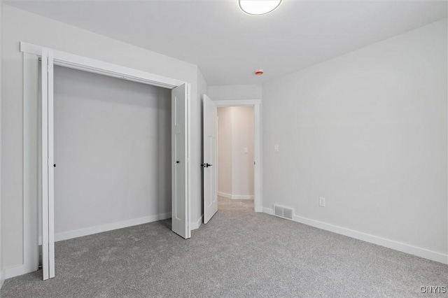 unfurnished bedroom featuring a closet, carpet, visible vents, and baseboards