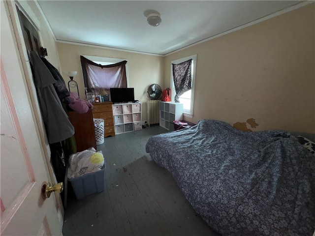 bedroom featuring radiator, wood-type flooring, and crown molding