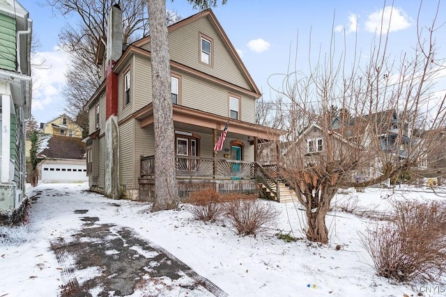 view of front of house featuring an outbuilding, a porch, and a chimney