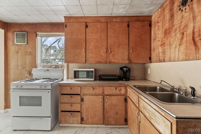 kitchen featuring gas range gas stove, a sink, visible vents, marble finish floor, and stainless steel microwave