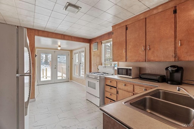 kitchen featuring white appliances, a sink, visible vents, marble finish floor, and french doors