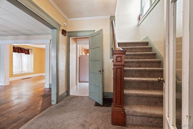 stairway with ornamental molding and baseboards