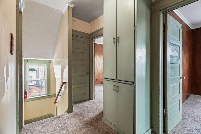 hallway with carpet, an upstairs landing, and crown molding