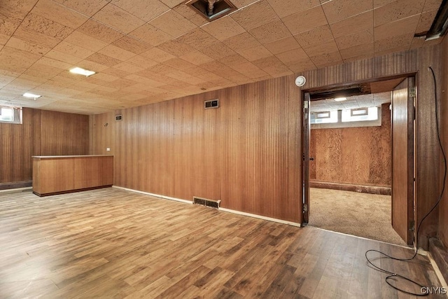 interior space with visible vents, wooden walls, and wood finished floors