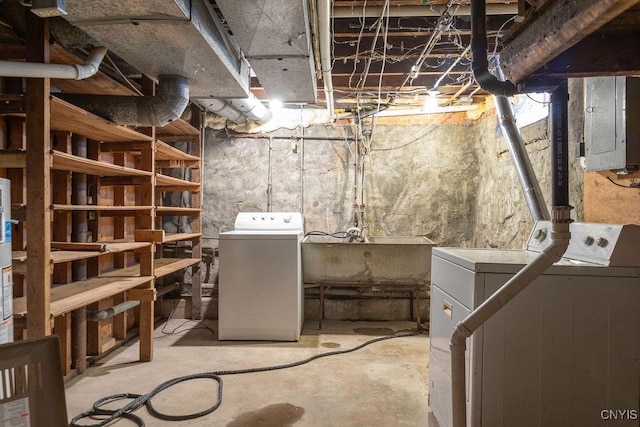 unfinished basement with electric panel, a sink, and independent washer and dryer