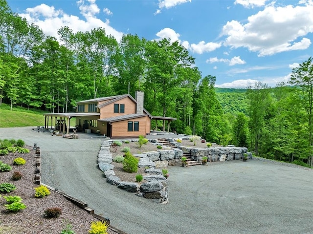 surrounding community featuring driveway and a view of trees