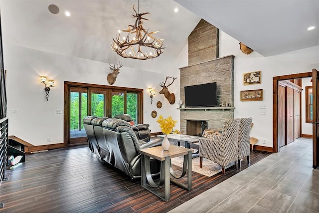 living room featuring a fireplace, high vaulted ceiling, wood finished floors, a chandelier, and baseboards