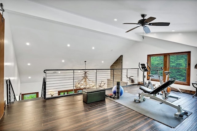 workout room with lofted ceiling, a barn door, recessed lighting, and wood finished floors