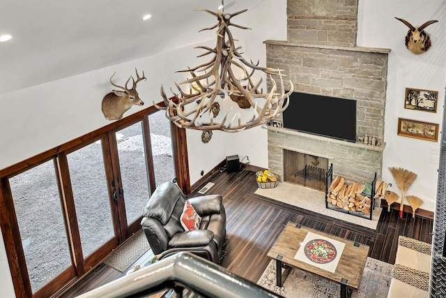 living room featuring a stone fireplace, recessed lighting, wood finished floors, and baseboards