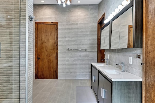 bathroom featuring double vanity, tile walls, a tile shower, and a sink