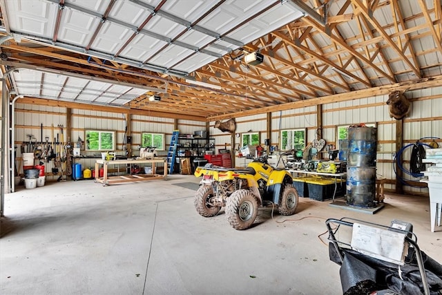 garage featuring a garage door opener, a workshop area, and metal wall