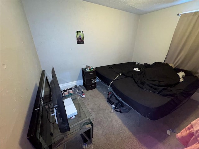 carpeted bedroom featuring a textured ceiling and baseboards