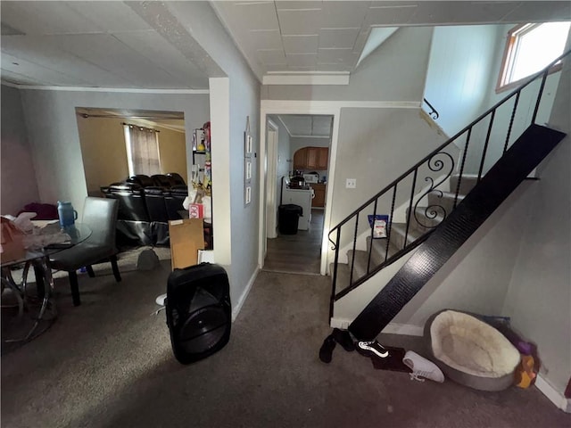 foyer featuring baseboards and stairs