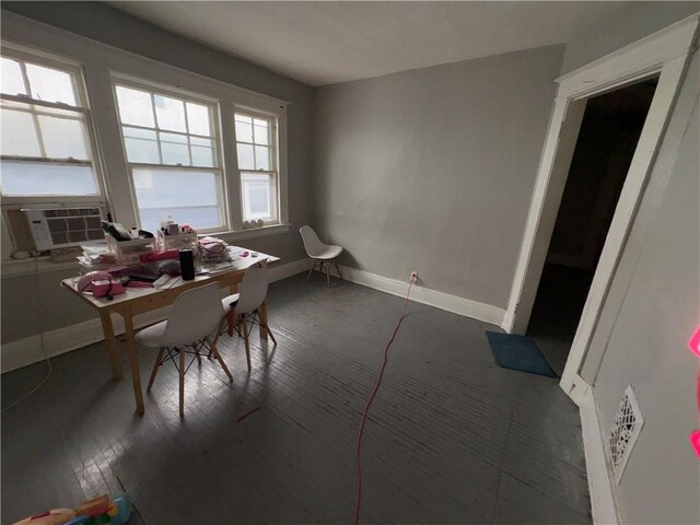 dining area featuring hardwood / wood-style flooring, baseboards, and cooling unit