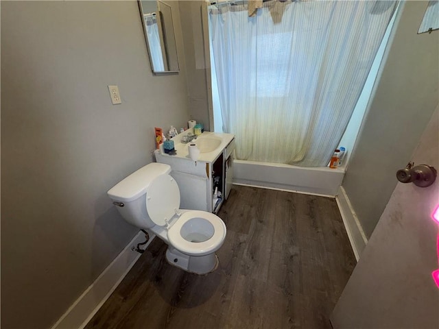 bathroom featuring toilet, wood finished floors, vanity, baseboards, and shower / bath combination with curtain