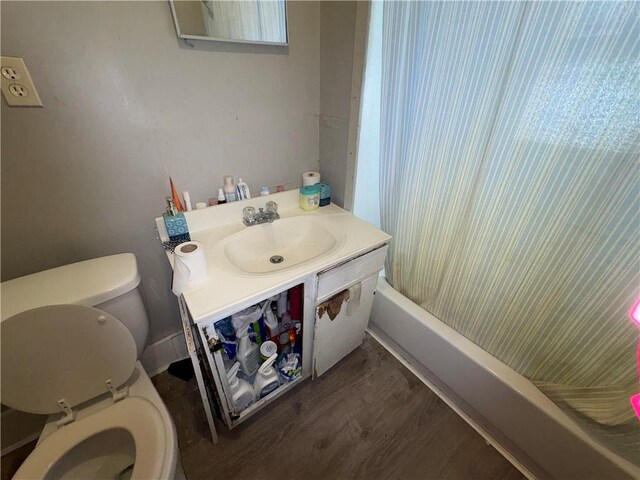 bathroom featuring shower / bath combo, vanity, toilet, and wood finished floors