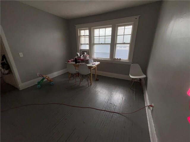 unfurnished dining area with wood-type flooring and baseboards