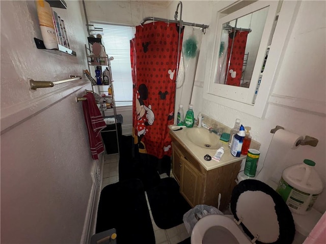 full bathroom with toilet, a textured wall, curtained shower, and vanity