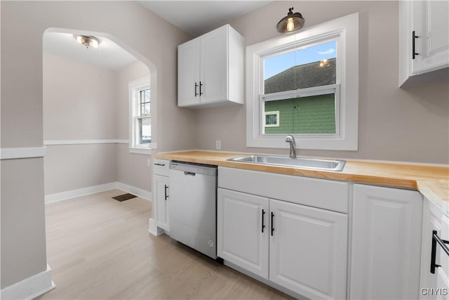 kitchen featuring light wood-type flooring, white cabinetry, dishwasher, and a sink