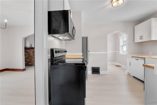 kitchen featuring arched walkways, range with electric stovetop, visible vents, white cabinetry, and dishwasher