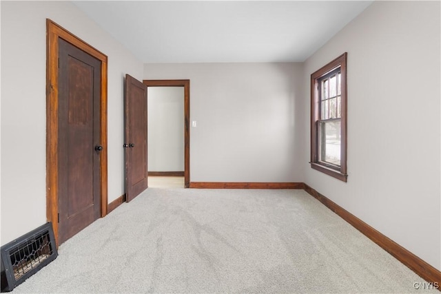 empty room with light carpet, visible vents, and baseboards