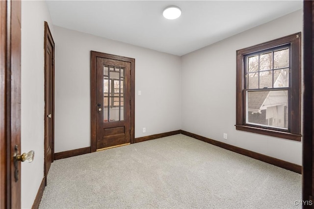 unfurnished room with carpet flooring and baseboards