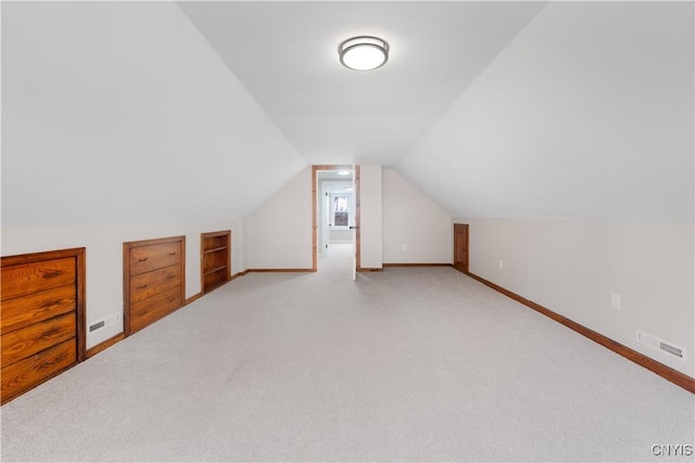 bonus room featuring baseboards, visible vents, built in features, lofted ceiling, and carpet floors