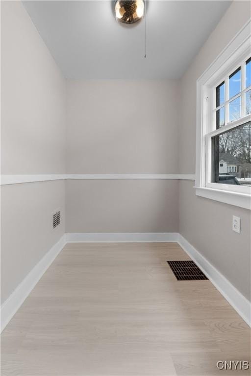 spare room with visible vents, baseboards, and wood finished floors