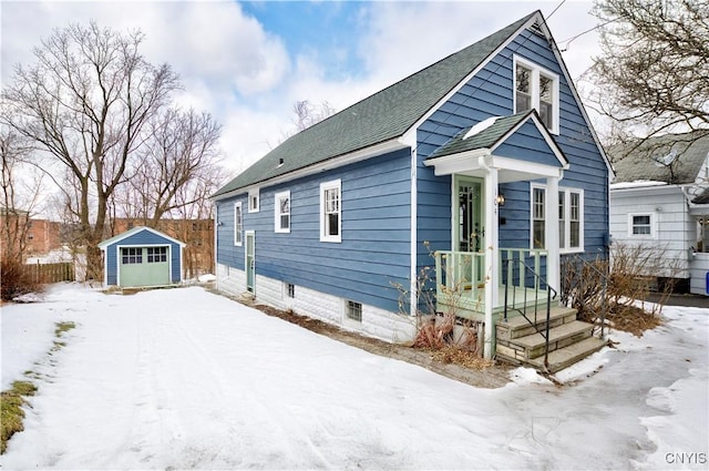 view of front of home featuring a garage, an outbuilding, roof with shingles, and a storage unit