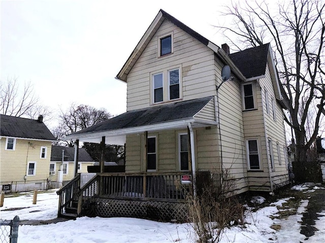 view of front of house featuring covered porch, a chimney, and roof with shingles