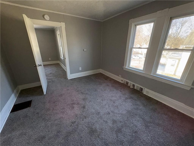 empty room featuring baseboards, dark carpet, and ornamental molding